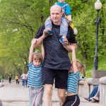 dad walks with three kids together in the park